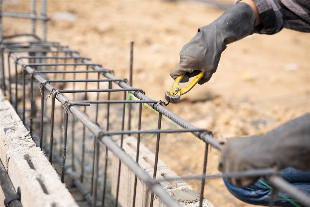 Worker tying rebar for a block wall