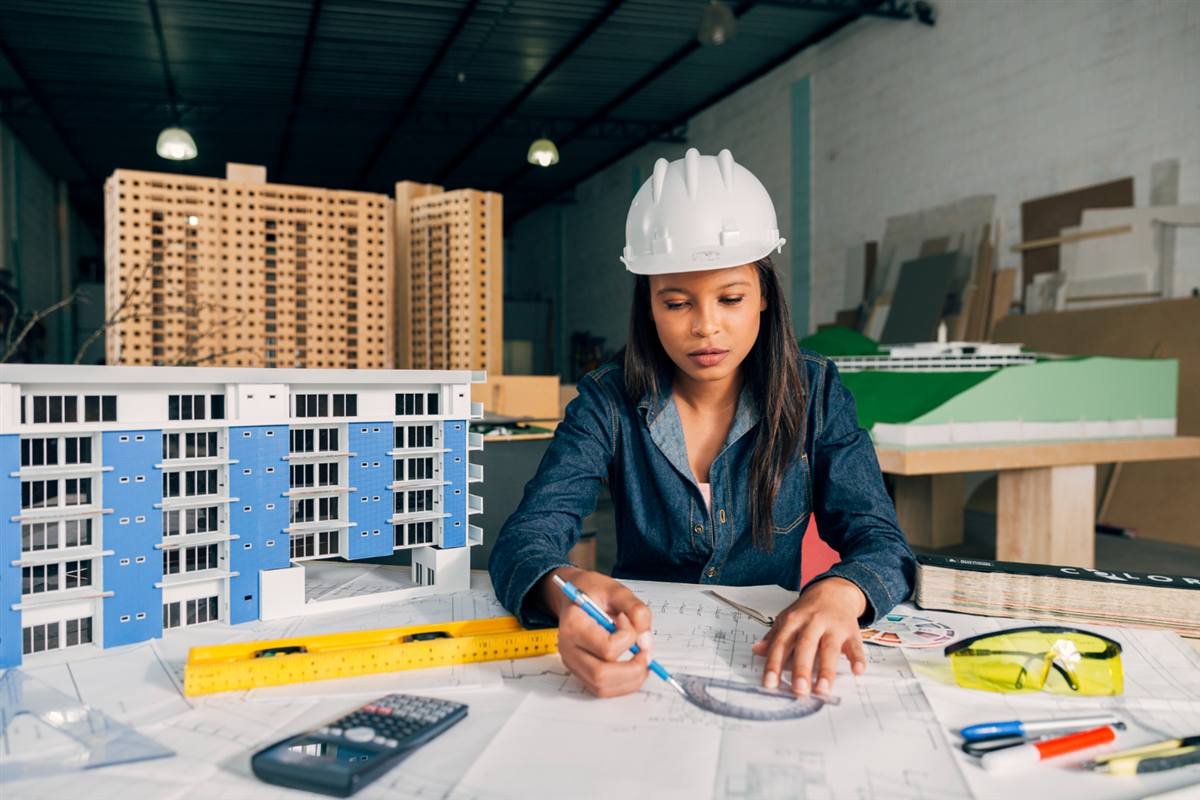 Architect reviewing building plans beside a scale model